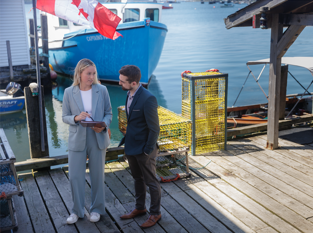 two people standing on a dock by the water