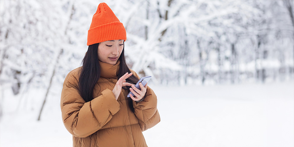 A student using a phone outside in winter
